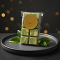 Matcha Dubai-Style Chocolate Bar on a dark ceramic plate with matcha leaves